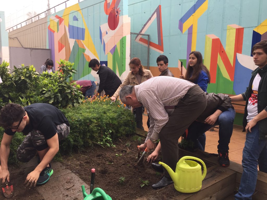 Alumnes de l’escola Isabel de Villena plantant flors juntament amb els usuaris de Sant Joan de Déu Serveis Sociosanitaris.
